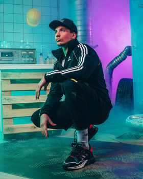 Glasbenik Žan Serčič v črno oranžnih zx-icah.